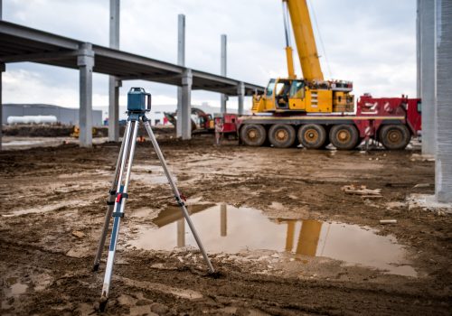 Engenharia industrial com teodolito, gps, estação total e ferramentas no canteiro de obras ao ar livre durante o trabalho de levantamento