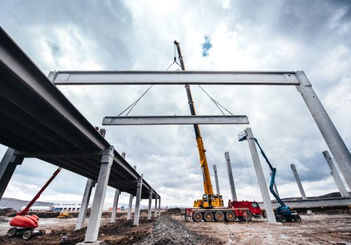 Local de construção industrial com guindastes de torre trabalhando com elementos pré-fabricados